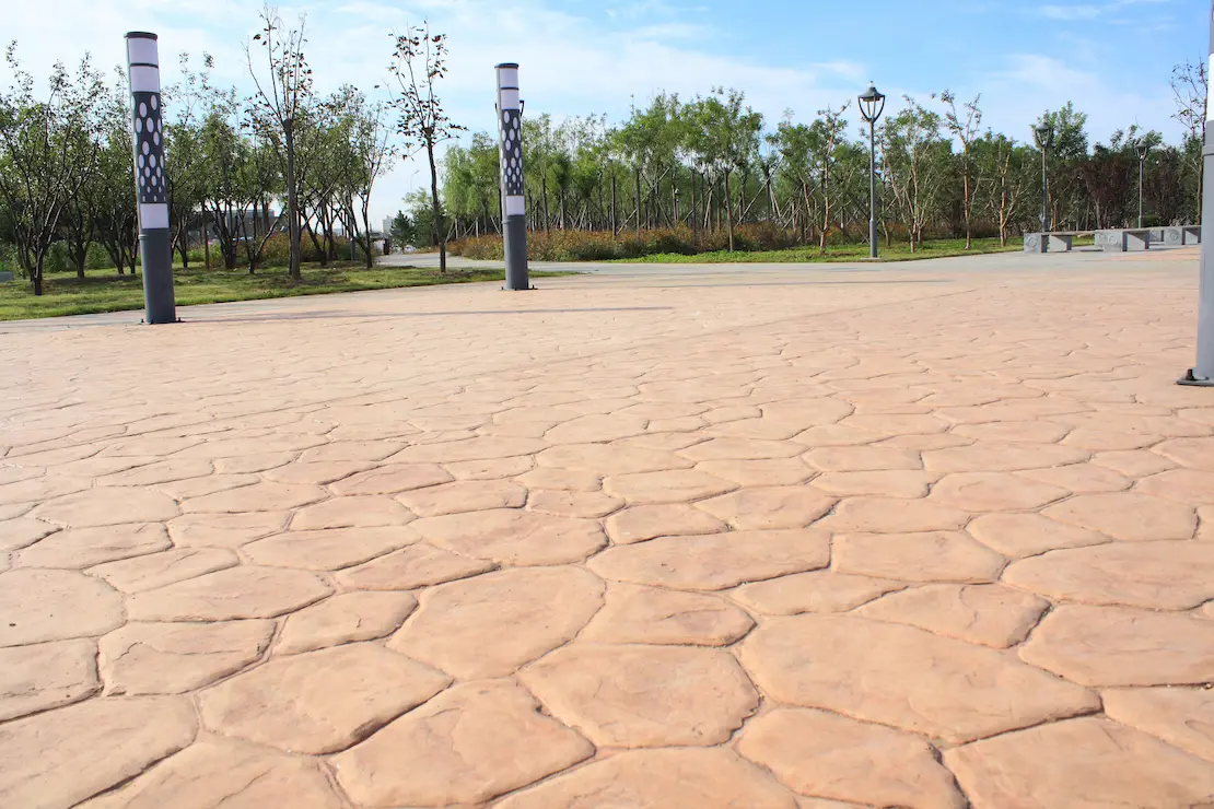 Zona de relajación de una institución educativa con pavimento de hormigón impreso.